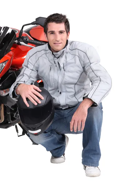 Homem ajoelhado de moto — Fotografia de Stock