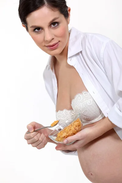 Mujer joven embarazada comiendo cereales — Foto de Stock