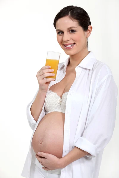 Schwangere trinkt ein Glas Saft — Stockfoto