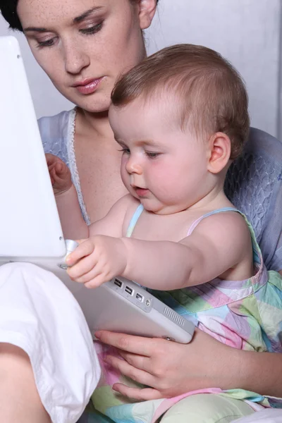 Barnet leka med hennes mors laptop — Stockfoto