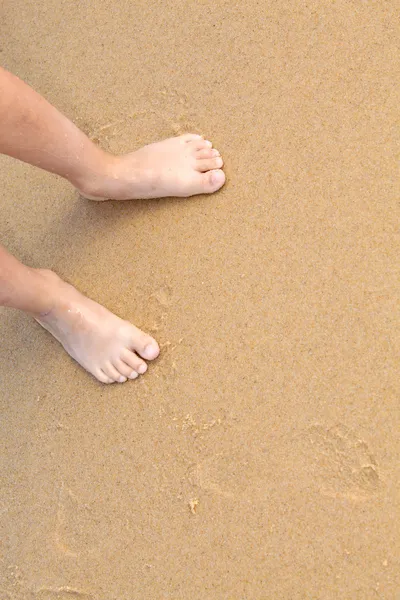 Голі ноги на піщаному пляжі — стокове фото