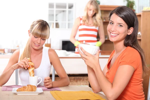 Unga kvinnor äter frukost hemma — Stockfoto