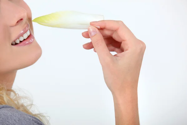 Vrouw eten witlof — Stockfoto