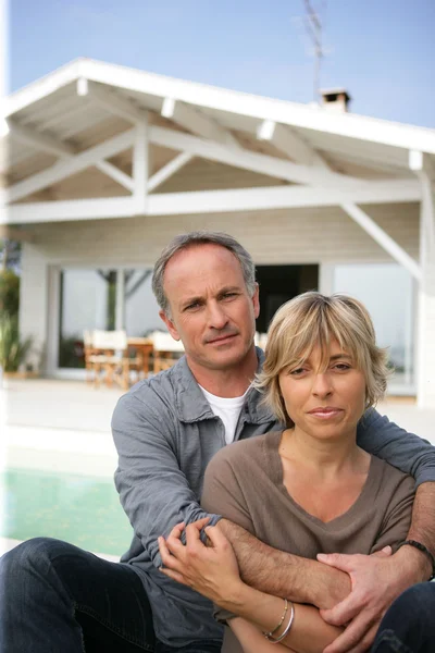 Couple relaxing by the pool — Stock Photo, Image