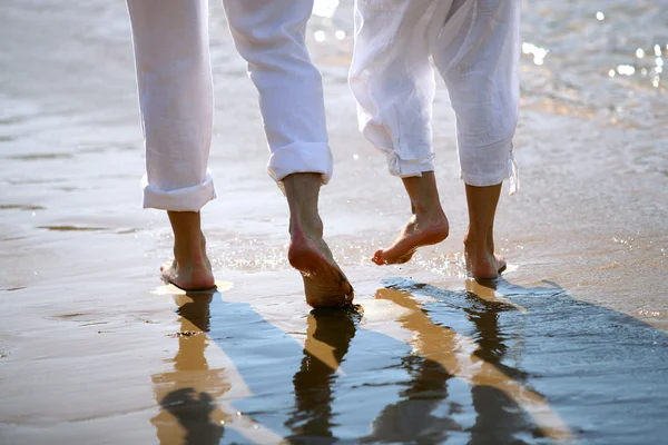 Pareja caminando descalza por el mar — Foto de Stock