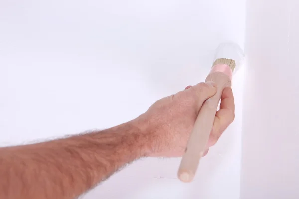 Homem parede de pintura com escova — Fotografia de Stock