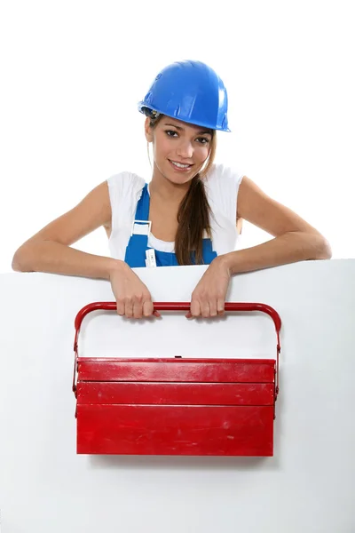 Trabalhadora feminina com caixa de ferramentas ficou atrás do quadro de mensagens — Fotografia de Stock