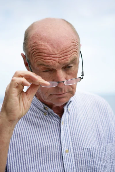 Homem mais velho olhando sobre seus óculos — Fotografia de Stock