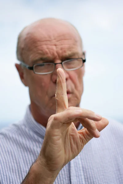 Stern vieil homme agitant son doigt — Photo