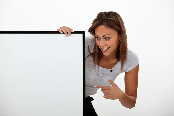 Woman painting to a blank sign — Stock Photo, Image