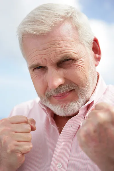 Senior man met zijn vuisten omhoog voor een gevecht — Stockfoto