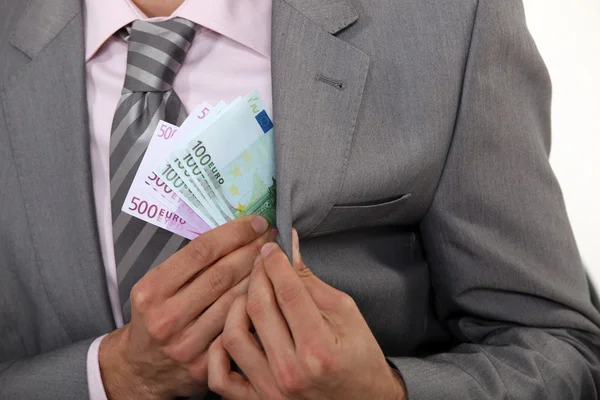 Businessman pulling money out of pocket — Stock Photo, Image