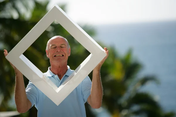 Man holding a white frame outdoors — Stock Photo, Image