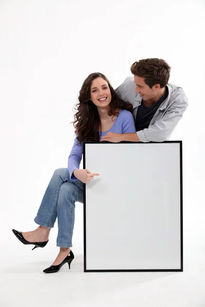 Casal com uma moldura deixada em branco para a sua imagem — Fotografia de Stock
