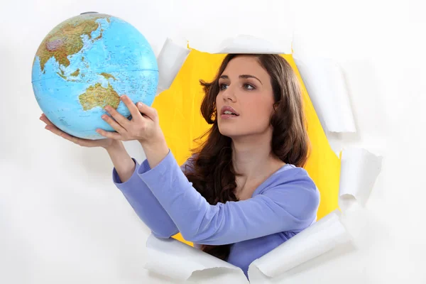 Woman getting out of hole with globe — Stock Photo, Image