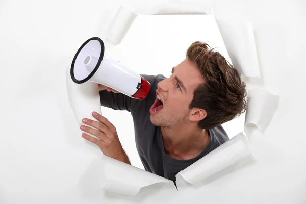 Молодой человек кричит в мегафон — стоковое фото