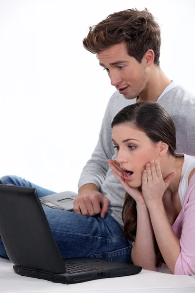 Couple choqué regardant ordinateur portable — Photo