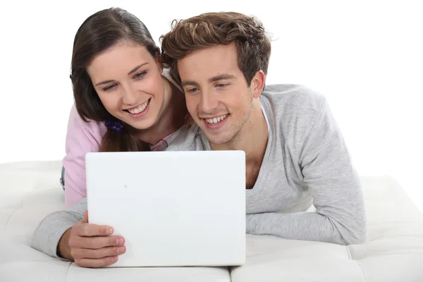 Casal jovem na frente de seu laptop — Fotografia de Stock