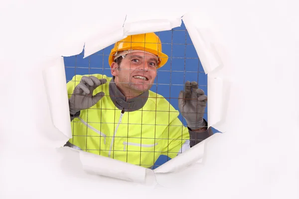Construction worker behind wire fence — Stock Photo, Image