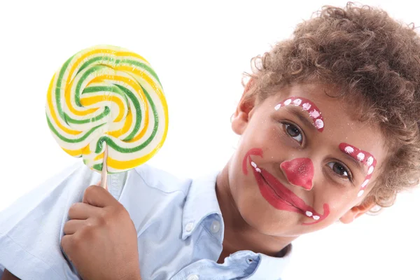 Child made-up with yellow lollipop — Stock Photo, Image