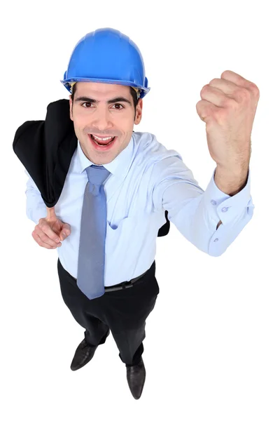 Empresário usando capacete levantando o punho — Fotografia de Stock