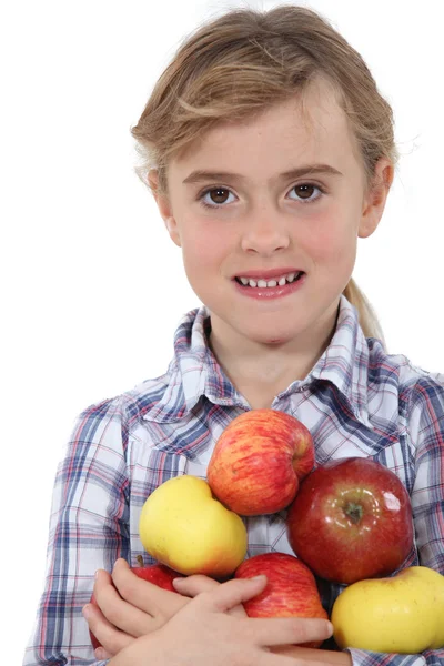 Маленькая девочка держит яблоки — стоковое фото