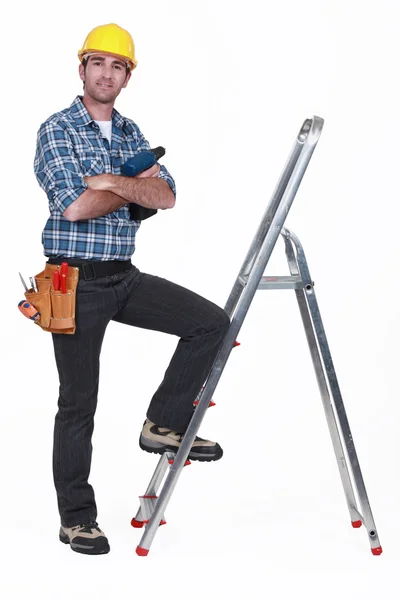 Portrait of a tradesman with his foot propped on a stepladder — Stok fotoğraf