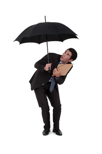 Бизнесмен обнаруживает дыру в зонтике — стоковое фото
