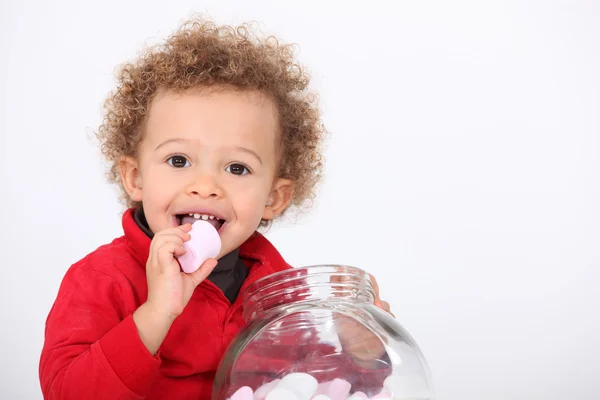 Un bambino carino che mangia marshmallow — Foto Stock