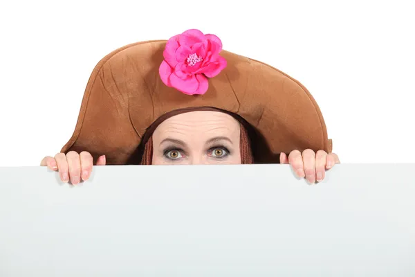 Femme se cachant portant un grand chapeau brun — Photo