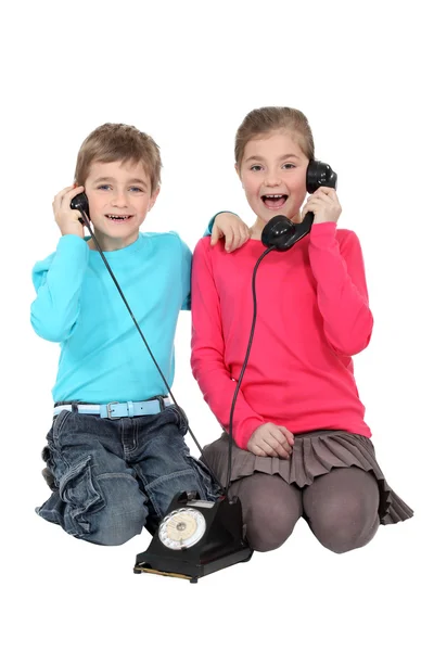 Crianças com um telefone antigo — Fotografia de Stock
