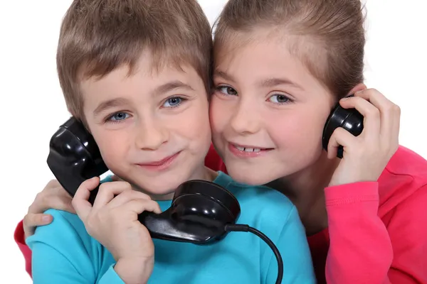 Брат и сестра со старомодным телефоном — стоковое фото