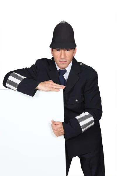 Policeman with blank advertising board — Stock Photo, Image