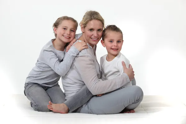 Mãe abraçando suas duas meninas — Fotografia de Stock
