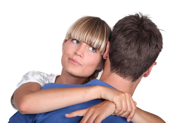 Jovem mulher abraçando seu namorado com um olhar de incerteza — Fotografia de Stock