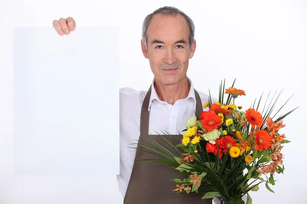 Мужчина-флорист держит доску объявлений — стоковое фото
