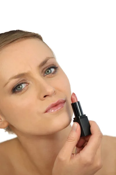 Woman putting lipstick Stock Image