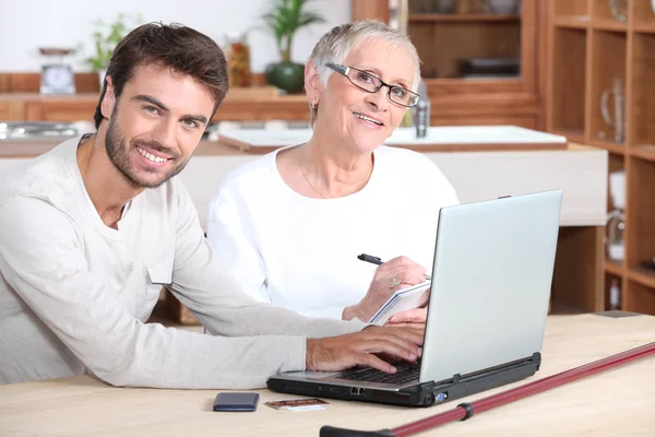 Son att hjälpa mor på laptop — Stockfoto
