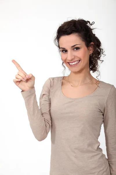 Portrait of cute young woman all smiles pointing sideways Stock Picture