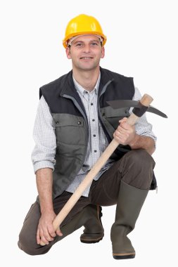 Man crouching with pick-ax clipart