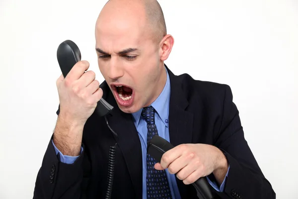 Man shouting angrily in receiver — Stock Photo, Image