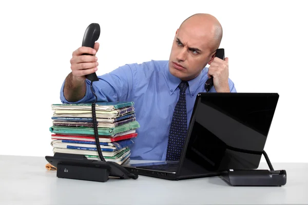 Affärsman som kämpar med två telefonsamtal — Stockfoto