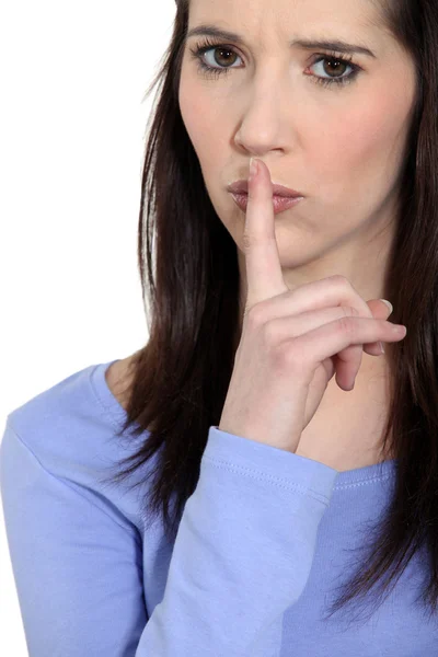 Mulher irritada segurando o dedo nos lábios — Fotografia de Stock