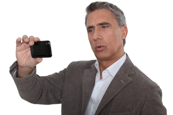 Zakenman kijken iets op zijn mobiele telefoon — Stockfoto