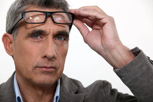 Muž zvyšování jeho brýle — Stock fotografie
