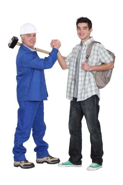 Senior craftsman and young apprentice shaking hands — Stock Photo, Image