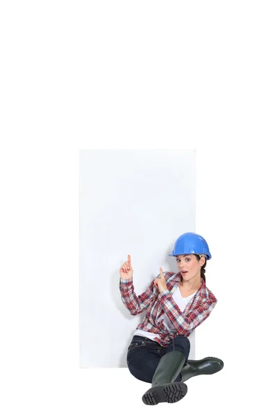 Trabalhadora da construção feminina apontando para o copyspace — Fotografia de Stock