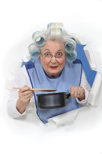 Oudere dame roeren saus pan — Stockfoto
