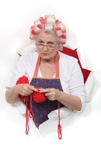 Granny with her hair in rollers and knitting — Stock Photo, Image