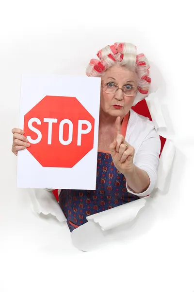 Γιαγιά που κρατάει μια πινακίδα stop και με τα μαλλιά της σε κυλίνδρους — Φωτογραφία Αρχείου